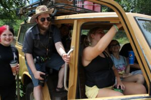 Robby and some students sitting in the hollowed out body of a jeep at the Louisville Zoo.